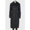 A woolen coat with a fur collar and brooch