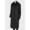 A woolen coat with a fur collar and brooch