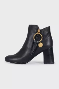 Black leather ankle boots with a gold pendant