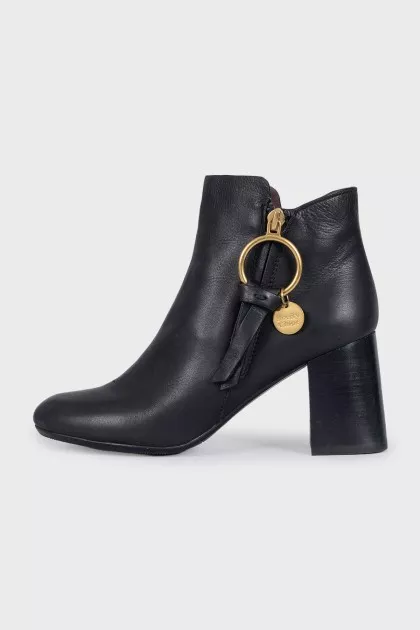 Black leather ankle boots with a gold pendant