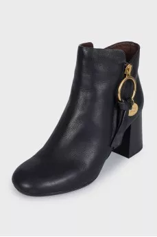 Black leather ankle boots with a gold pendant