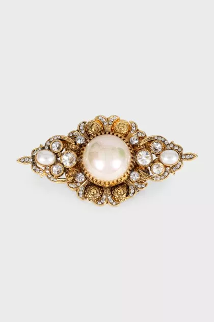 Golden brooch with decor