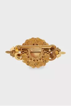 Golden brooch with decor