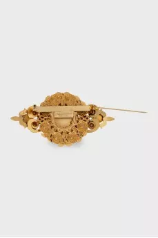 Golden brooch with decor