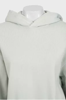 Green hoodie with a logo on the sleeve