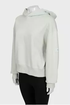 Green hoodie with a logo on the sleeve