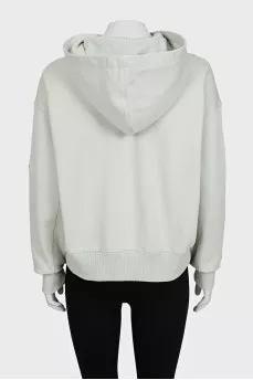 Green hoodie with a logo on the sleeve