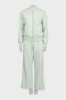 The green tracksuit is decorated with stripes