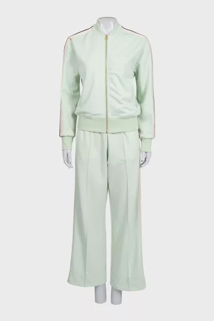 The green tracksuit is decorated with stripes