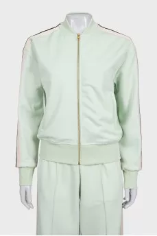 The green tracksuit is decorated with stripes