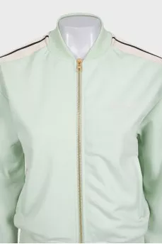 The green tracksuit is decorated with stripes
