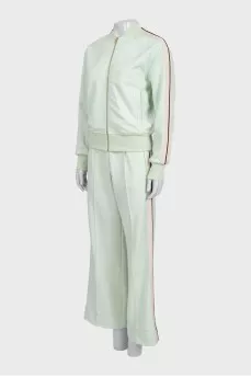 The green tracksuit is decorated with stripes