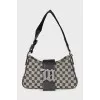 A textile shoulder bag with a signature print