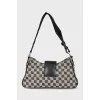 A textile shoulder bag with a signature print