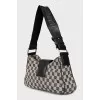 A textile shoulder bag with a signature print