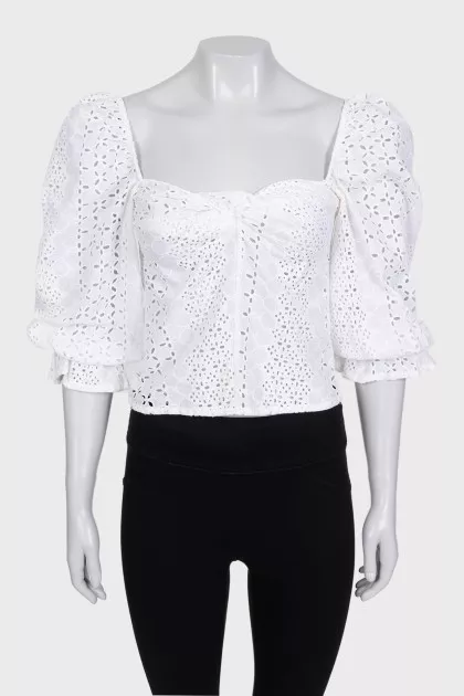 White blouse with puffed sleeves decorated with perforations