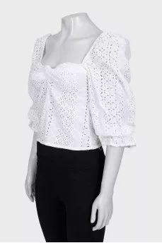 White blouse with puffed sleeves decorated with perforations