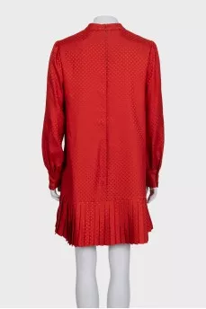 Red dress with long sleeves decorated with perforations