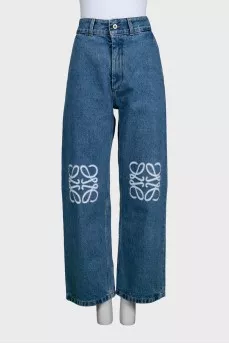 Blue jeans with branded embroidery on the knees