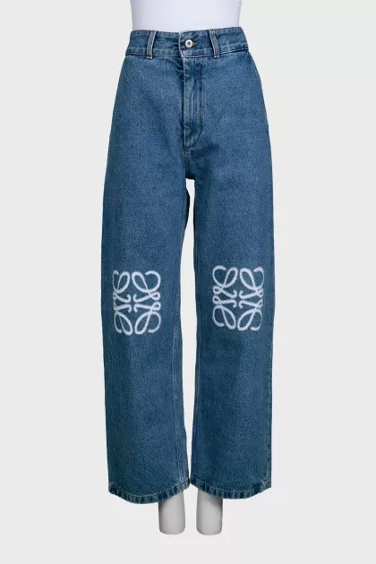 Blue jeans with branded embroidery on the knees