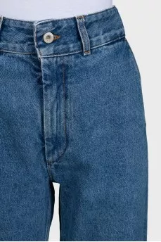 Blue jeans with branded embroidery on the knees