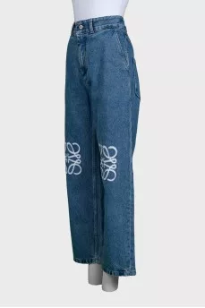Blue jeans with branded embroidery on the knees