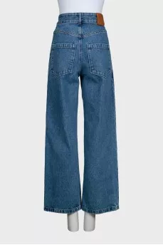Blue jeans with branded embroidery on the knees