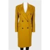 Mustard coat on a double -breasted fastener, with a tag
