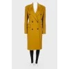 Mustard coat on a double -breasted fastener, with a tag