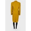 Mustard coat on a double -breasted fastener, with a tag