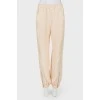 Beige pants with zips at the bottom