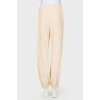 Beige pants with zips at the bottom